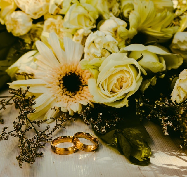 Prstenovi pored cvetnog buketa / Rings beside flower bouquet